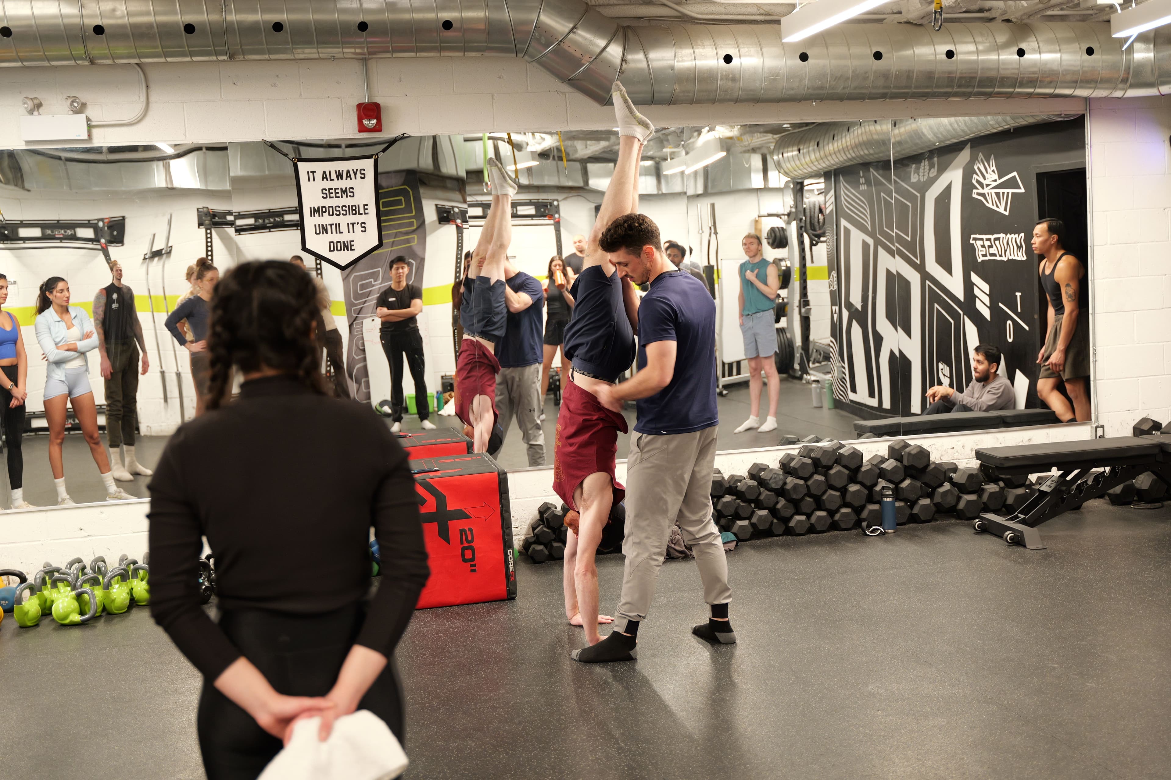 Jonny spotting a student into a handstand with the full class visible