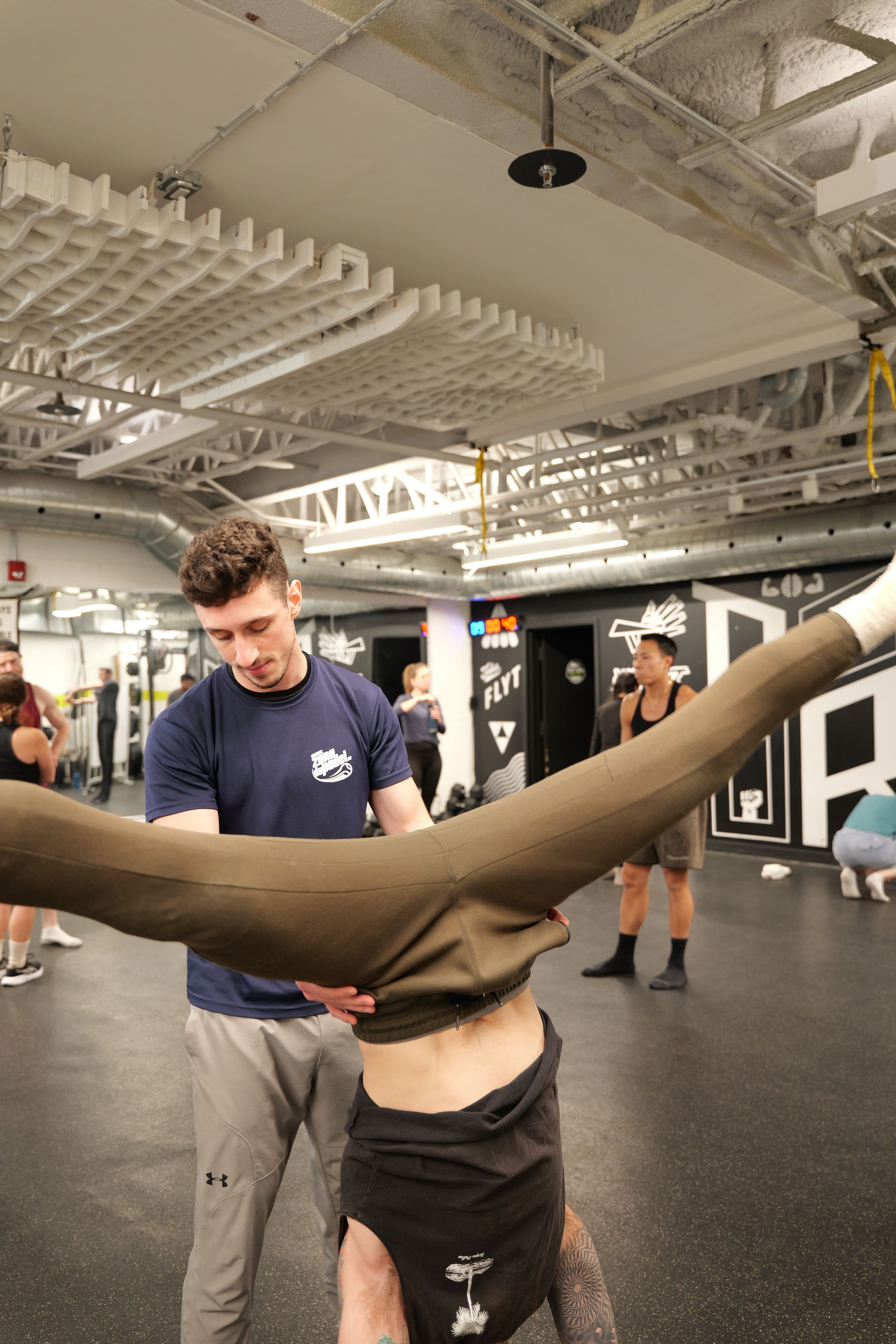Jonny watching a student's handstand, calm and focused