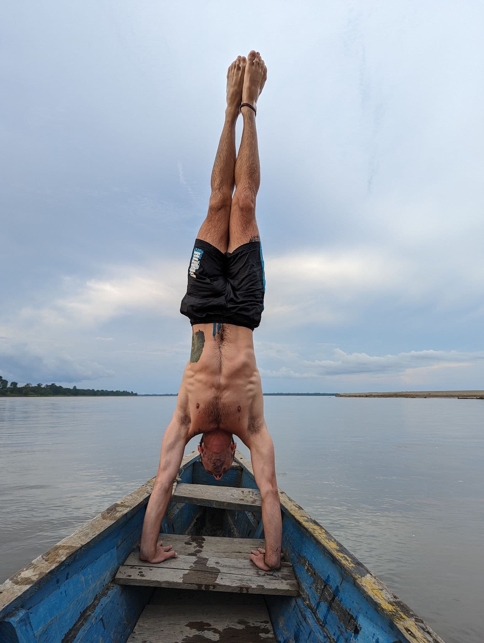 Handstand on the bow of a canoe on the Amazon river